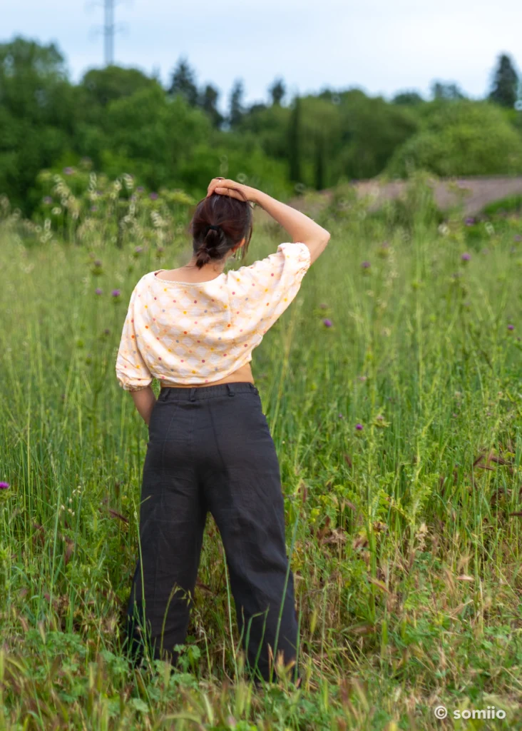 Pantalon Twig Woven Pant en lin bleu marine en mouvement, revers sur la cheville et baskets noires