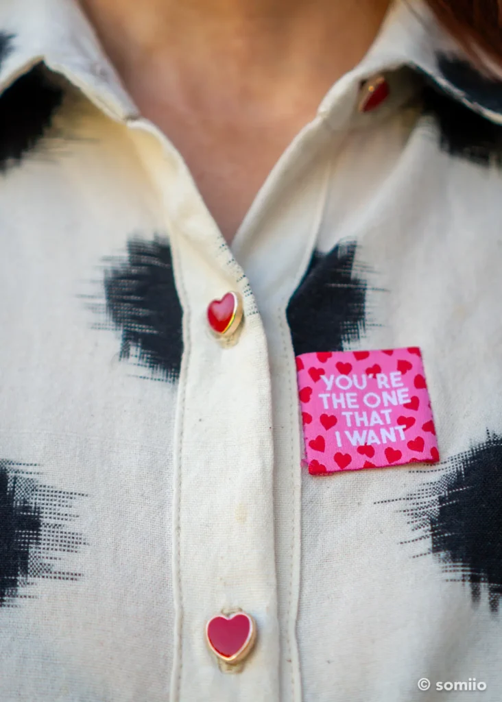 Boutons cœurs rouges et étiquette cousue sur le coton ikat